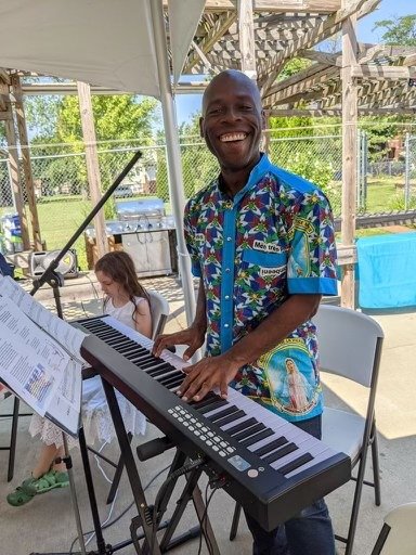 Frater Carl Gales SVD serves as pianist and cantor at an outdoor Mass at which a friend renewed temporary vows in the Society of the Divine Word.